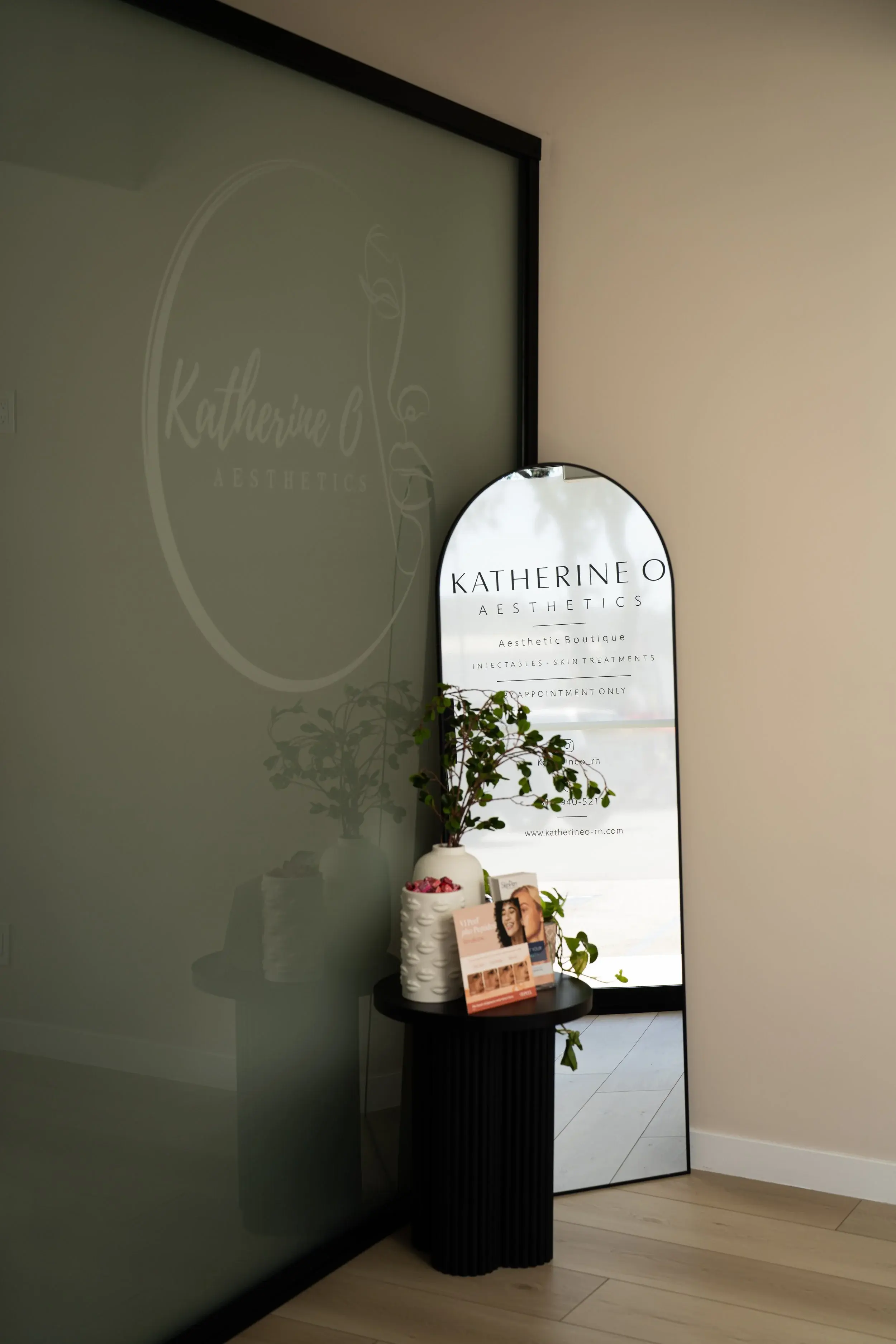 The boutique entry, with the frosted glass logo wall beside an arched sign reading by appointment only